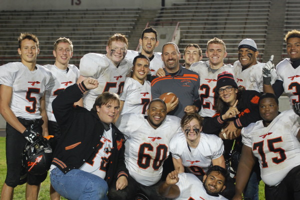Scott Parseghian wins his 100th football game as coach of Wayland High School with a 34-0 win versus Boston Latin. Coach P (in the center of the photo) celebrates with some of his team after the game. 
